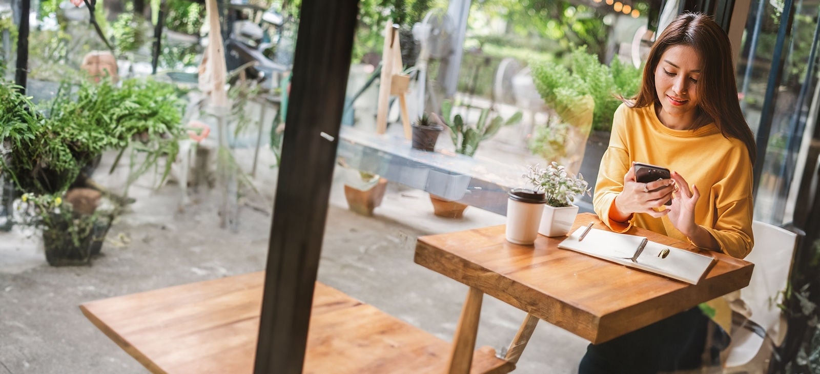 Young woman in coffee shop using smartphone